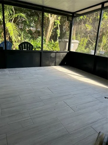 a view of empty room with wooden floor and windows