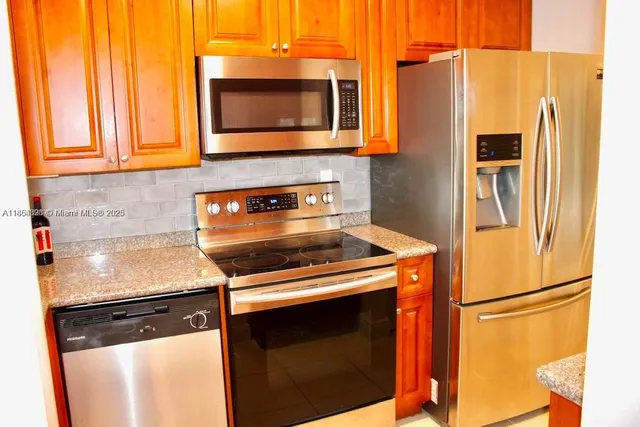 a kitchen with stainless steel appliances a stove microwave and a refrigerator