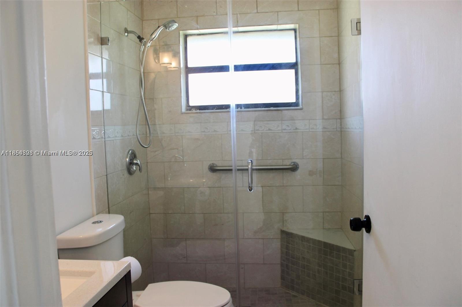 5181 Kim Court West Palm Beach, FL 33415 - Photo 8 of 24 a bathroom with a toilet and a shower