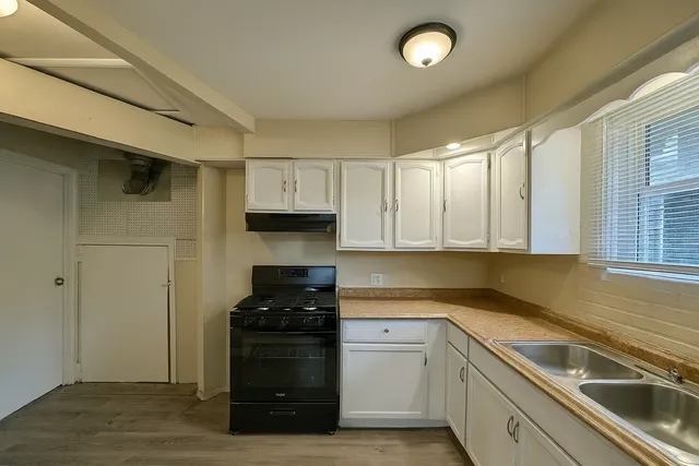 a kitchen with granite countertop a sink and a stove top oven