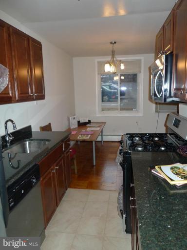 3000 7th Street Northeast, Unit 124 Washington, DC 20017 - Photo 2 of 27 a kitchen with a sink stove and cabinets
