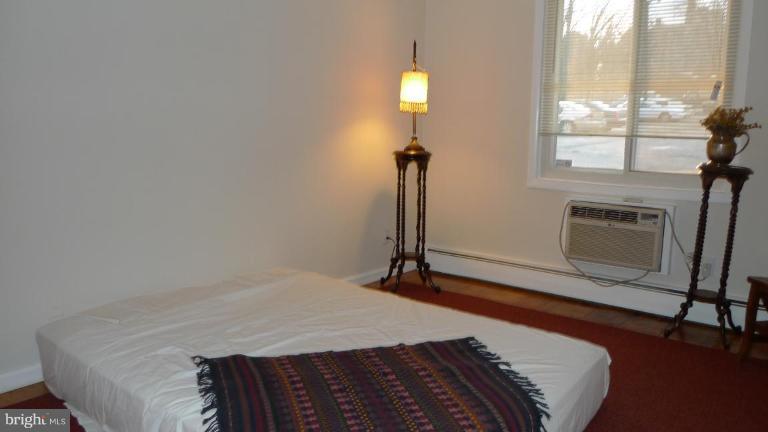3000 7th Street Northeast, Unit 124 Washington, DC 20017 - Photo 20 of 27 a bedroom with a bed and wooden floor