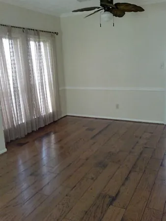 a view of a hardwood floor and window in a room