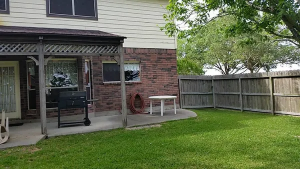 a view of a chair and table in backyard of the house