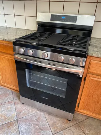 a stove top oven sitting inside of a kitchen