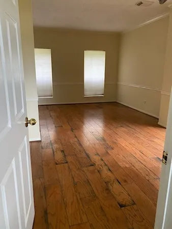 a view of empty room with wooden floor