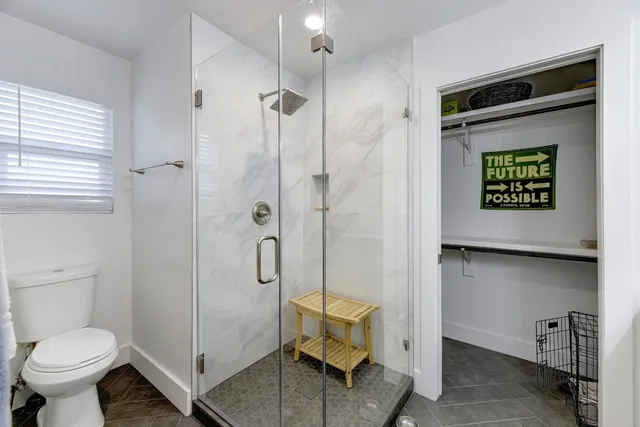 a bathroom with a toilet and a shower