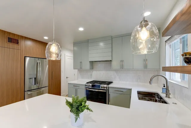 a kitchen with granite countertop a stove a sink and a refrigerator