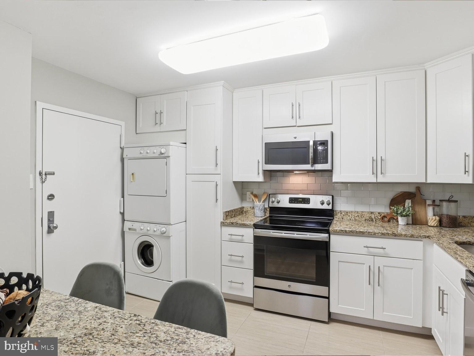 1800 Old Meadow Road, Unit 1017 McLean, VA 22102 - Photo 8 of 31 a kitchen with granite countertop a stove a sink and a microwave
