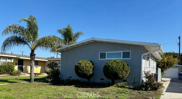 a view of a house with many windows next to a yard