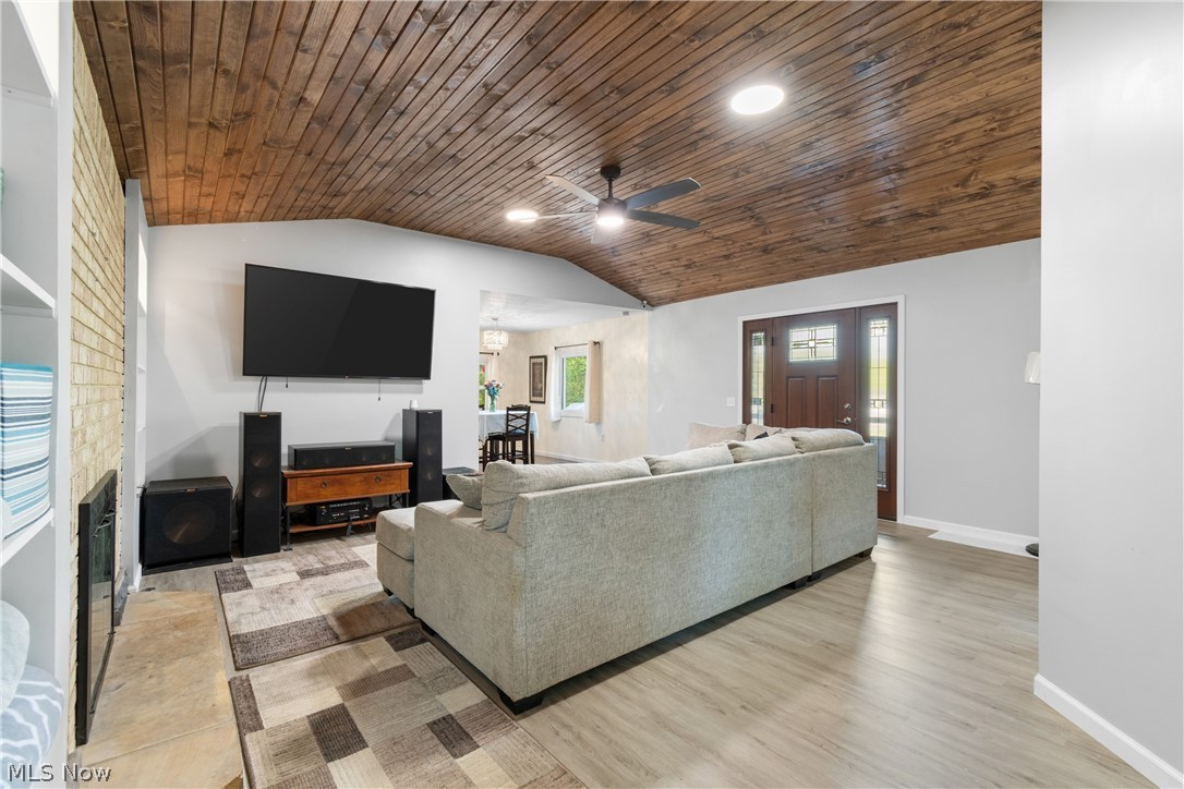 3255 Old Weymouth Road Medina, OH 44256 - Photo 5 of 31 Living room featuring light hardwood / wood-style floors, a fireplace, ceiling fan, wood ceiling, and lofted ceiling