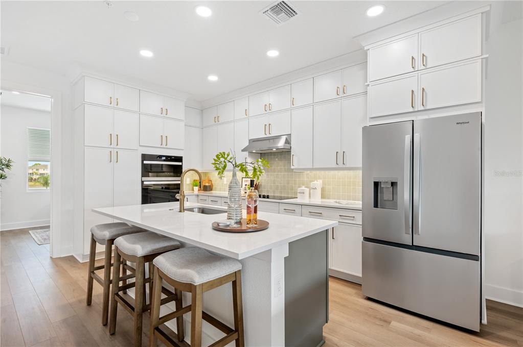 9992 Key Haven Road Seminole, FL 33777 - Photo 12 of 49 a kitchen with stainless steel appliances granite countertop a refrigerator a stove a sink a dining table and chairs