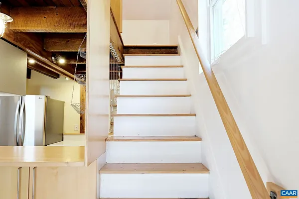 a view of staircase with white walls and railing