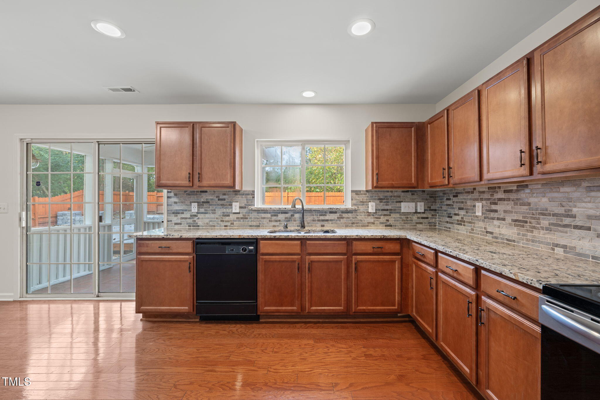 2816 Roundleaf Court Raleigh, NC 27604 - Photo 9 of 37 a kitchen with stainless steel appliances granite countertop wooden cabinets a sink and dishwasher a stove top oven with wooden floor