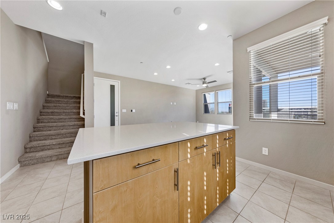 11238 Essence Point Avenue, Unit 201 Las Vegas, NV 89135 - Photo 52 of 52 Kitchen with a center island, recessed lighting, light tile patterned floors, light stone countertops, and open floor plan