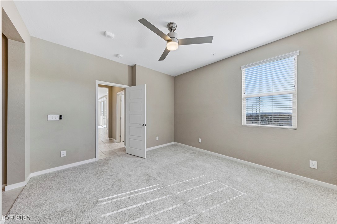 11238 Essence Point Avenue, Unit 201 Las Vegas, NV 89135 - Photo 19 of 52 Unfurnished bedroom featuring light colored carpet and a ceiling fan