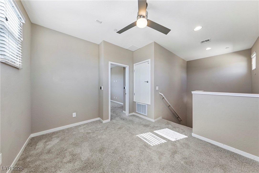 11238 Essence Point Avenue, Unit 201 Las Vegas, NV 89135 - Photo 22 of 52 Unfurnished room with light carpet and ceiling fan
