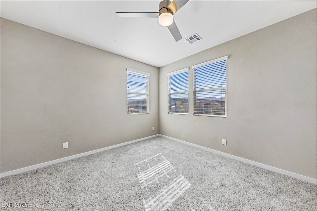 11238 Essence Point Avenue, Unit 201 Las Vegas, NV 89135 - Photo 23 of 52 Carpeted empty room with baseboards and ceiling fan