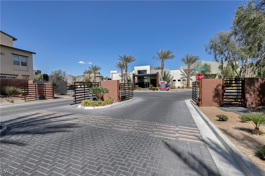 11238 Essence Point Avenue, Unit 201 Las Vegas, NV 89135 - Photo 30 of 52 View of decorative road featuring curbs, a gate, traffic signs, and a gated entry