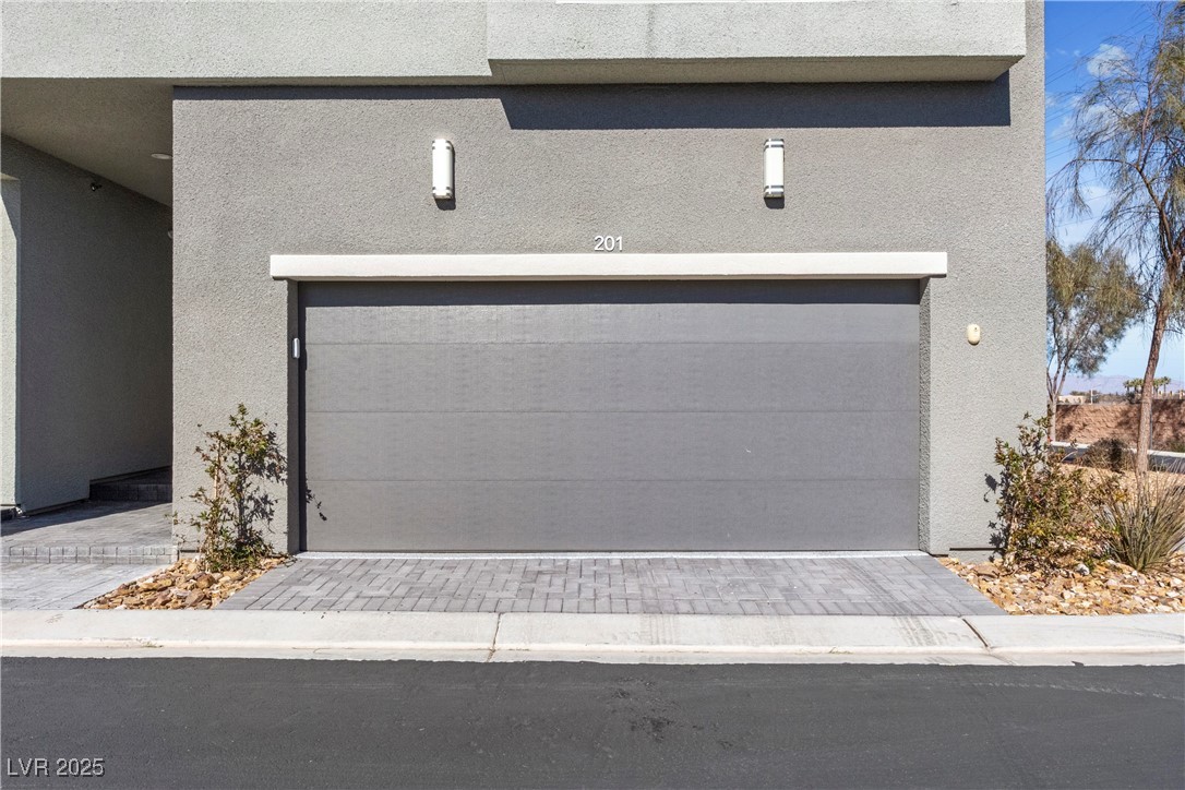 11238 Essence Point Avenue, Unit 201 Las Vegas, NV 89135 - Photo 9 of 52 Garage featuring decorative driveway