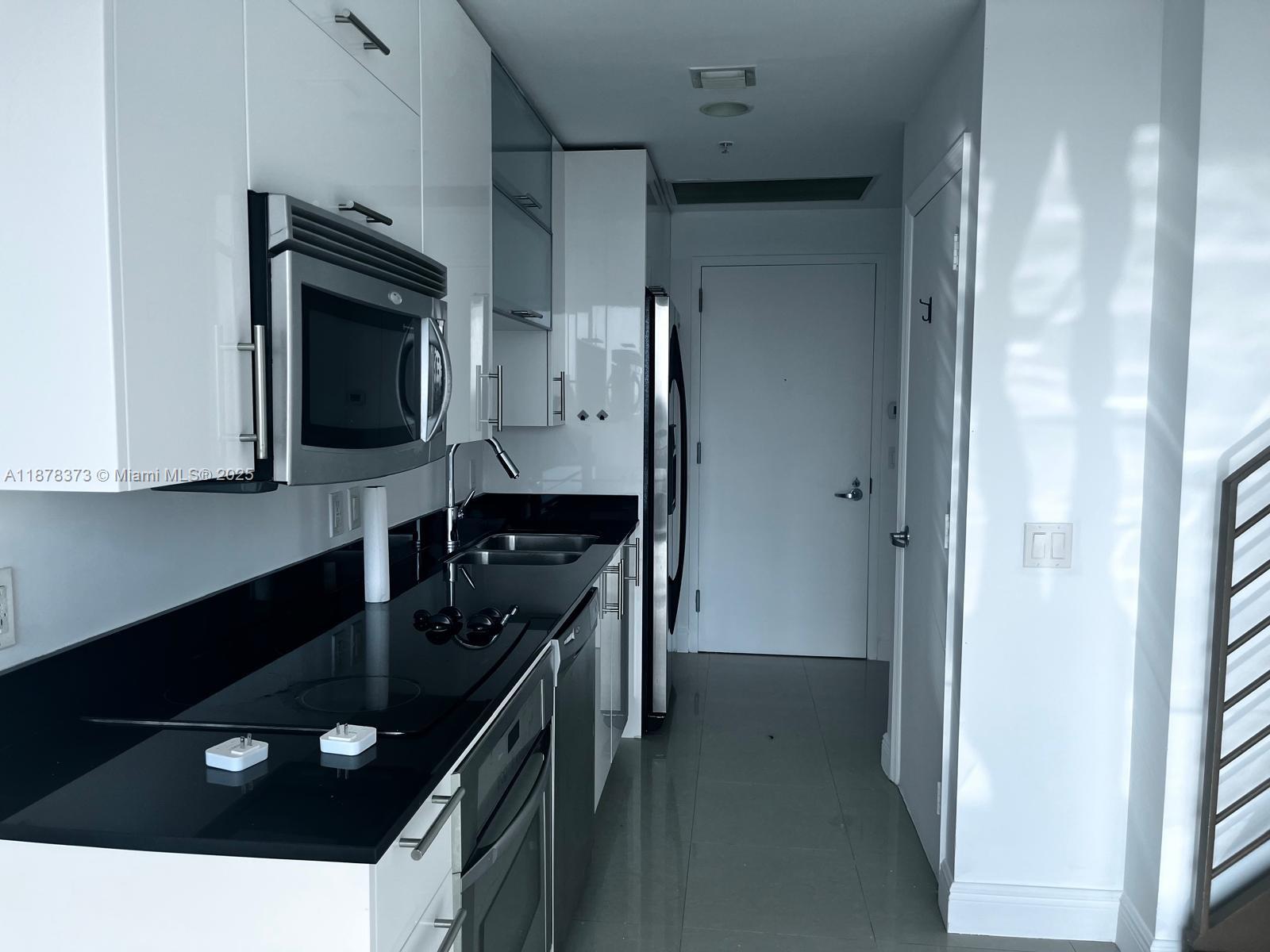 60 Southwest 13th Street, Unit 1417 Miami, FL 33130 - Photo 2 of 9 a kitchen with a sink appliances and cabinets