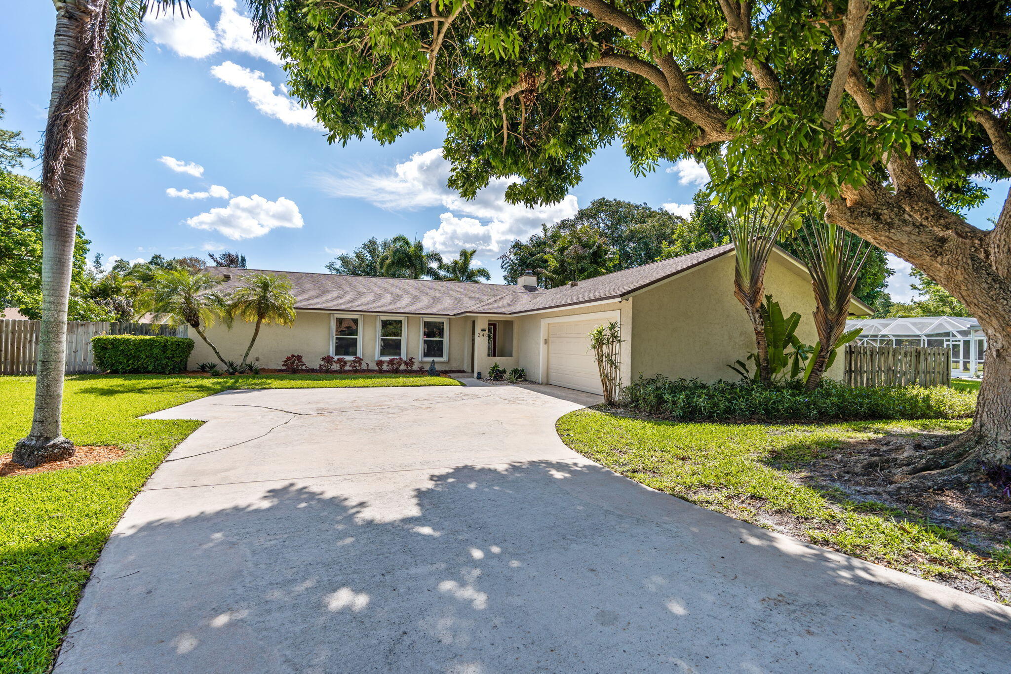 240 Sulky Way Wellington, FL 33414 - Photo 2 of 26 a front view of a house with a yard and garage