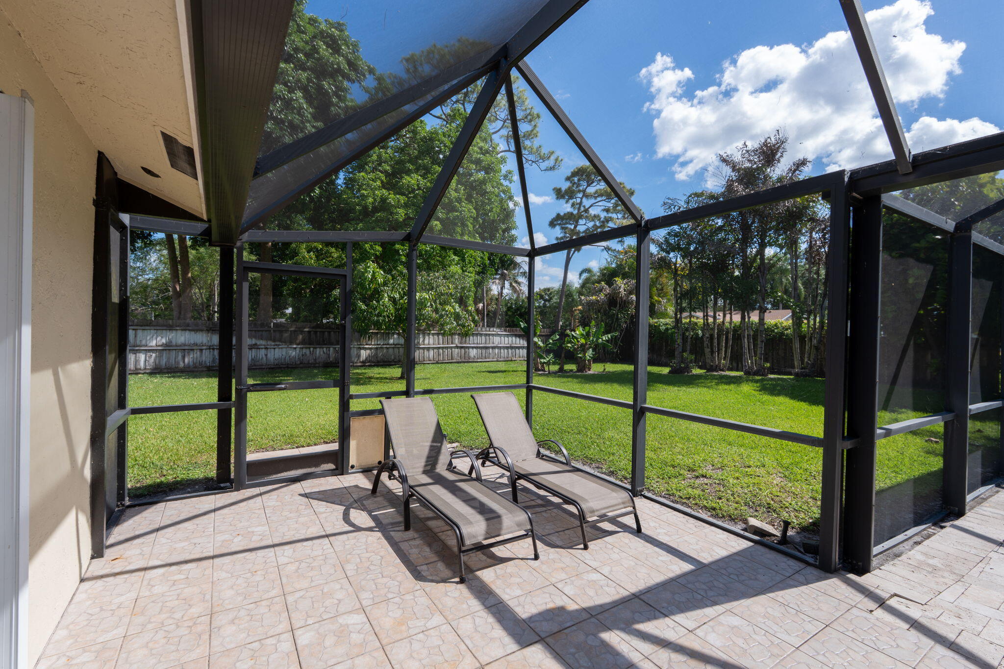 240 Sulky Way Wellington, FL 33414 - Photo 22 of 26 a view of a patio with a table chairs and a backyard