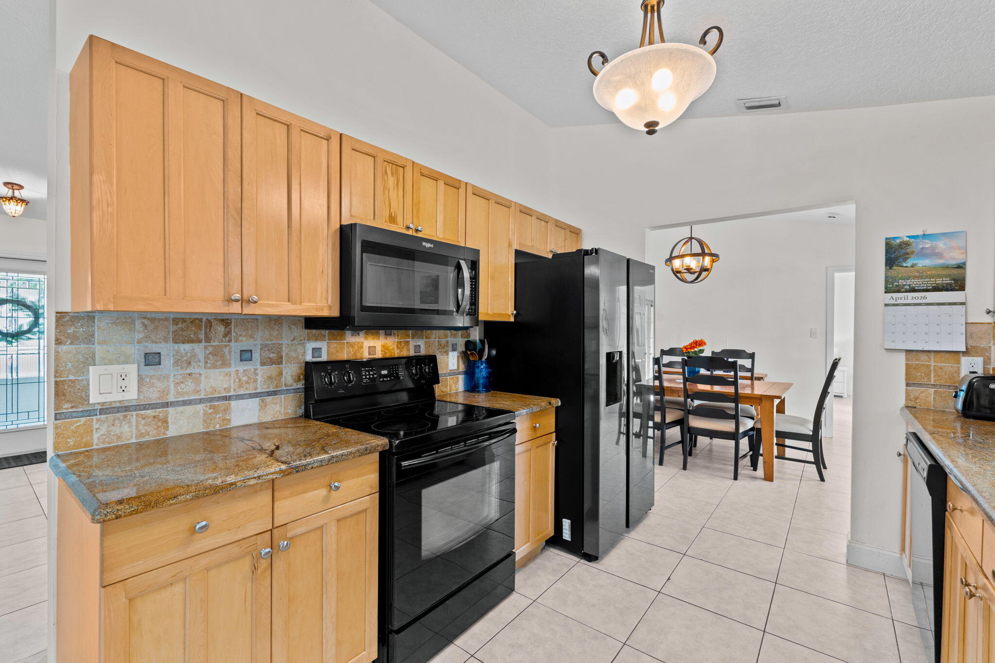 240 Sulky Way Wellington, FL 33414 - Photo 9 of 26 a kitchen with granite countertop a stove refrigerator and microwave