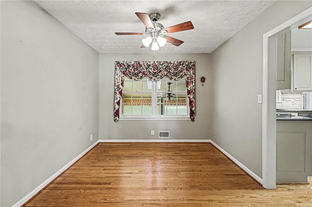 740 Smyrna Road Southwest Conyers, GA 30094 - Photo 10 of 27 wooden floor in an empty room with a window