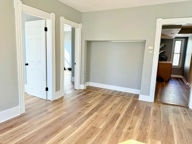 a view of a room with wooden floor and a bathroom