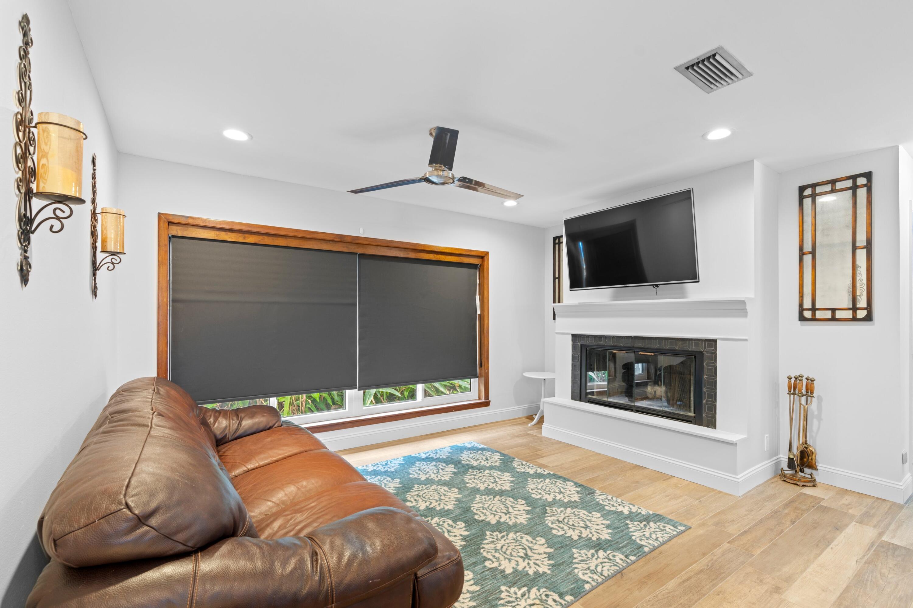 1039 Northwest 8th Street Boca Raton, FL 33486 - Photo 11 of 17 a living room with a fireplace and a flat screen tv
