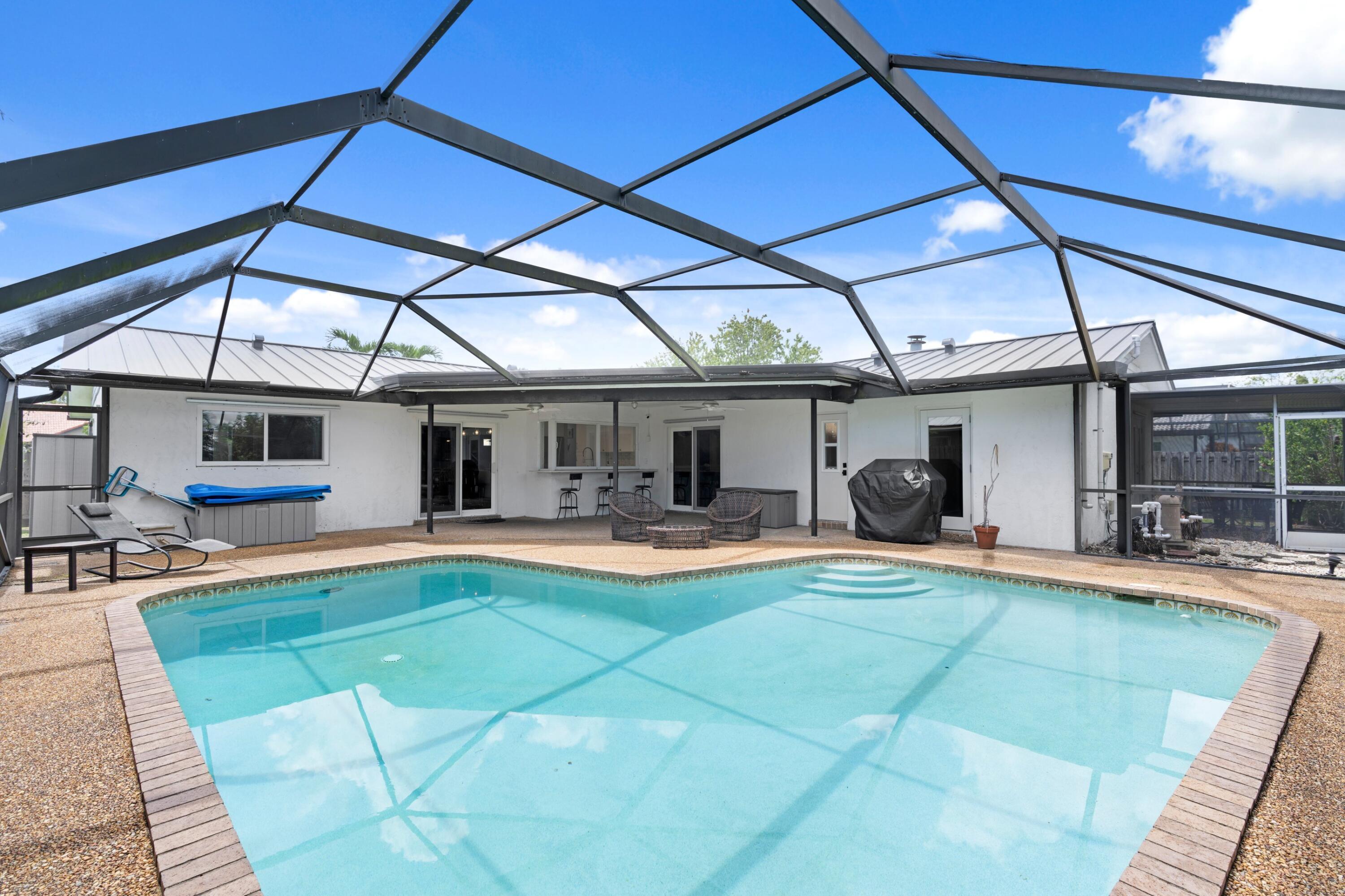 1039 Northwest 8th Street Boca Raton, FL 33486 - Photo 14 of 17 a view of a house with swimming pool and sitting area