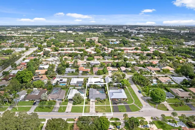 an aerial view of residential houses with outdoor space and trees