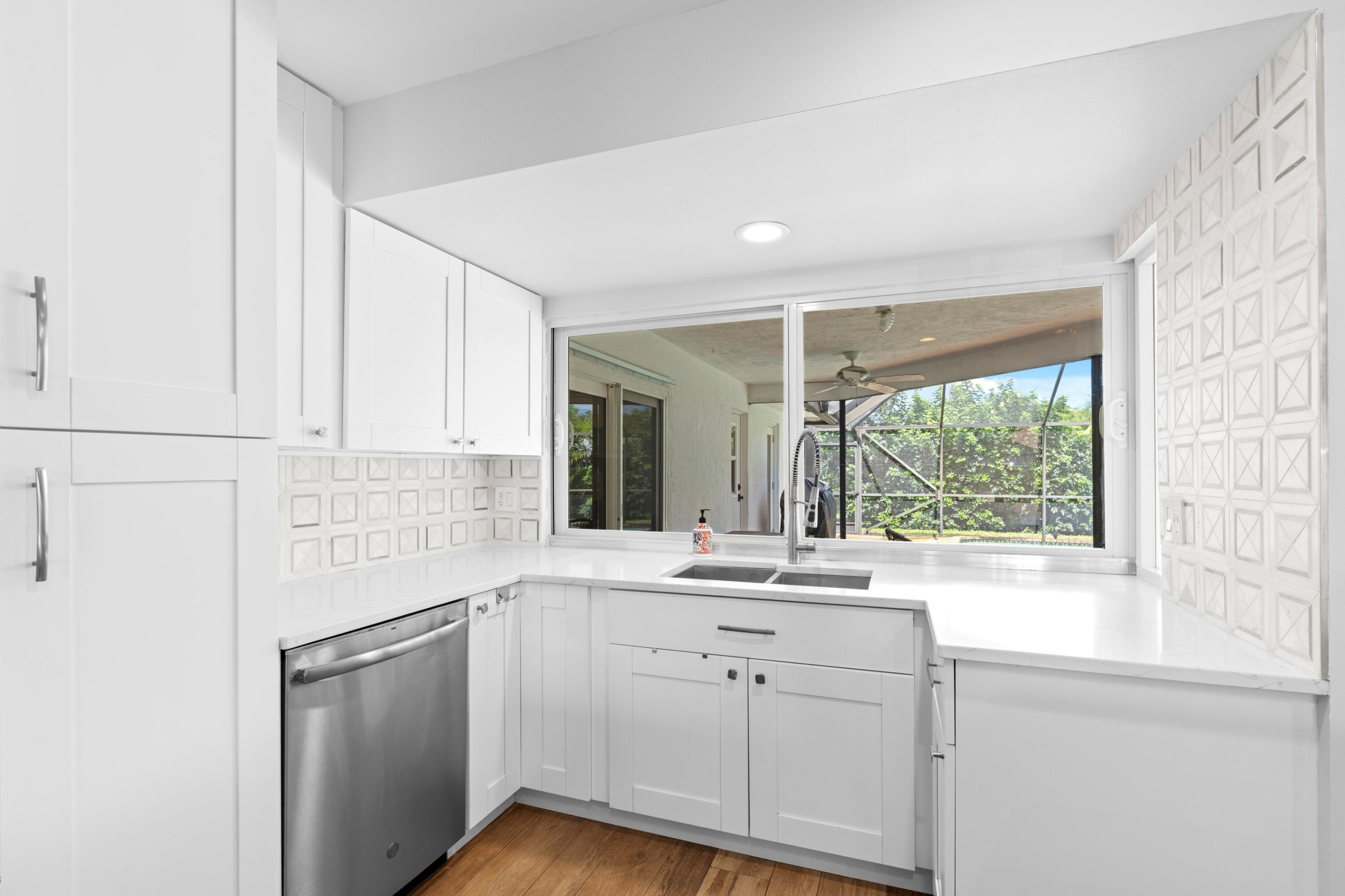1039 Northwest 8th Street Boca Raton, FL 33486 - Photo 6 of 17 a kitchen with a sink window and cabinets