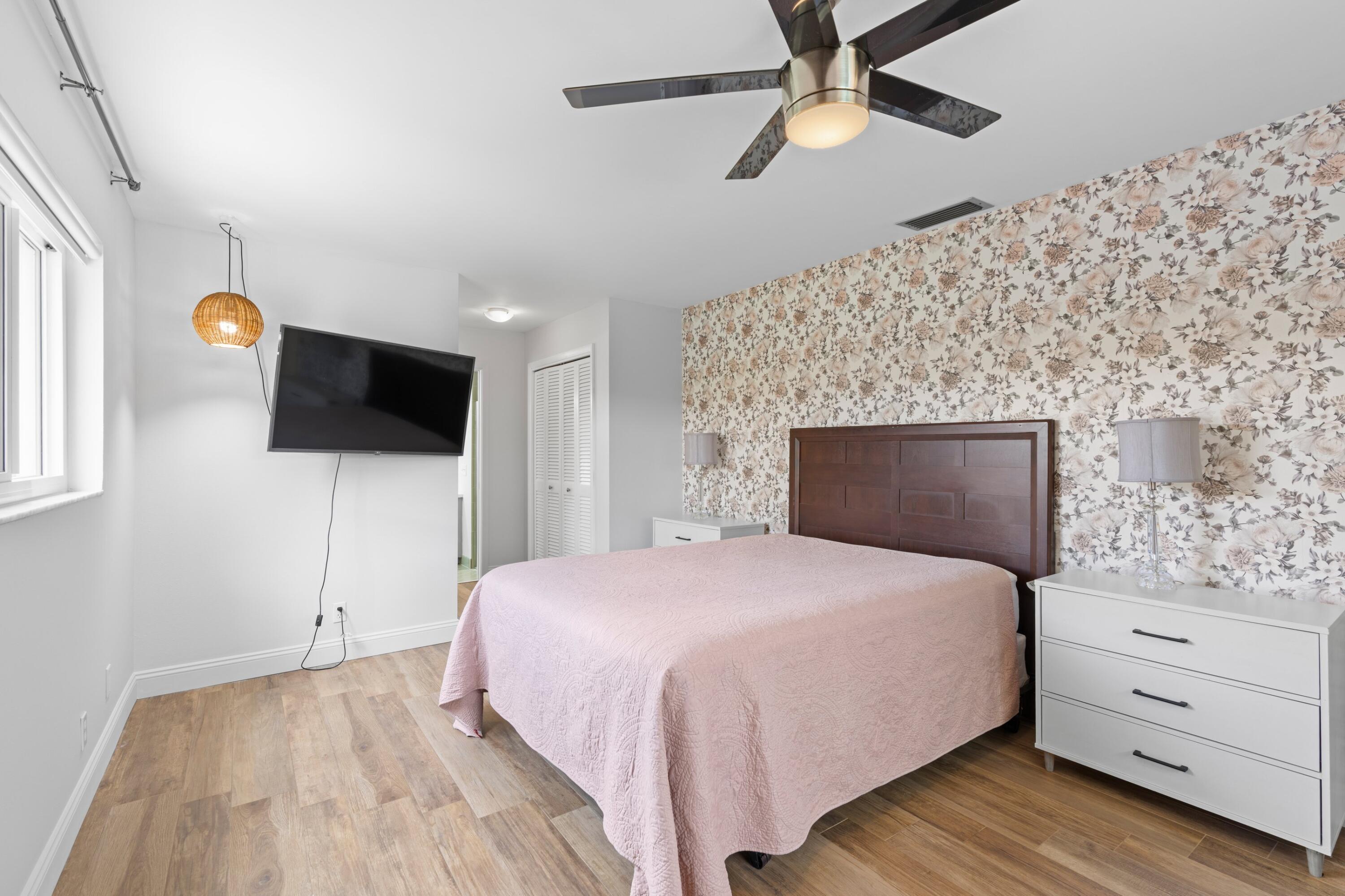 1039 Northwest 8th Street Boca Raton, FL 33486 - Photo 7 of 17 a bedroom with a bed and a flat tv screen on dresser