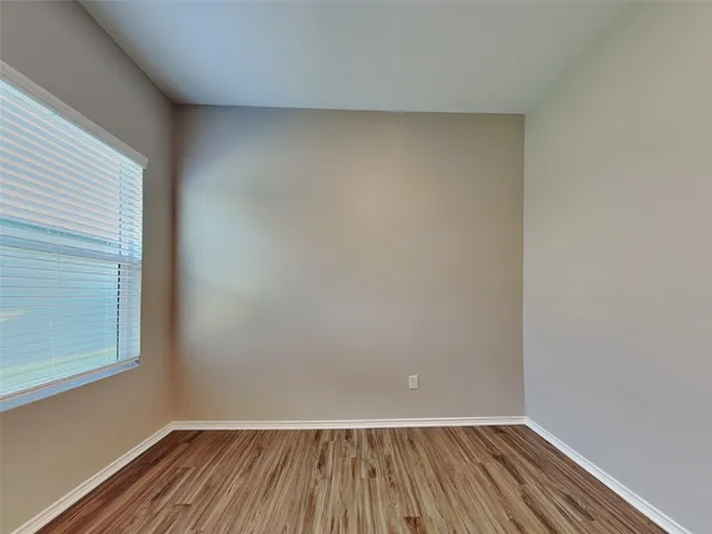 a view of a room with wooden floor and small window