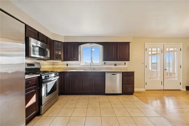 a kitchen with stainless steel appliances granite countertop a stove a sink dishwasher and a refrigerator
