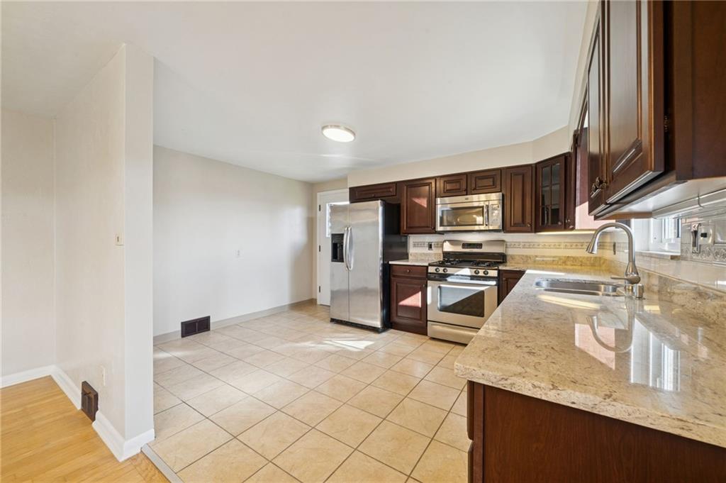 421 Robbins Station Road Irwin, PA 15642 - Photo 9 of 33 a kitchen with stainless steel appliances granite countertop a sink stove and refrigerator