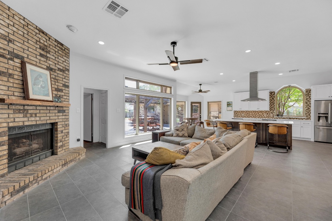2 Meandering Way Round Rock, TX 78664 - Photo 11 of 39 a living room with furniture a fireplace a chandelier and a flat screen tv