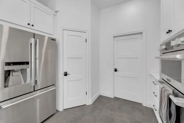 a view of kitchen with refrigerator and cabinets