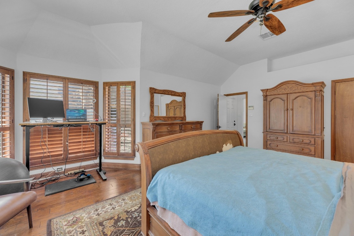 2 Meandering Way Round Rock, TX 78664 - Photo 22 of 39 a bedroom with a bed and wooden floor