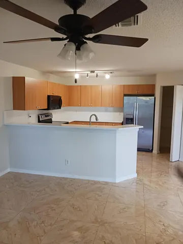 a kitchen with stainless steel appliances a sink a stove top oven a counter space and cabinets