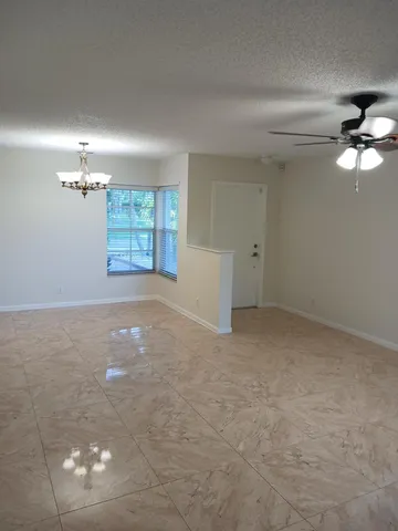 en empty room with windows and ceiling fan