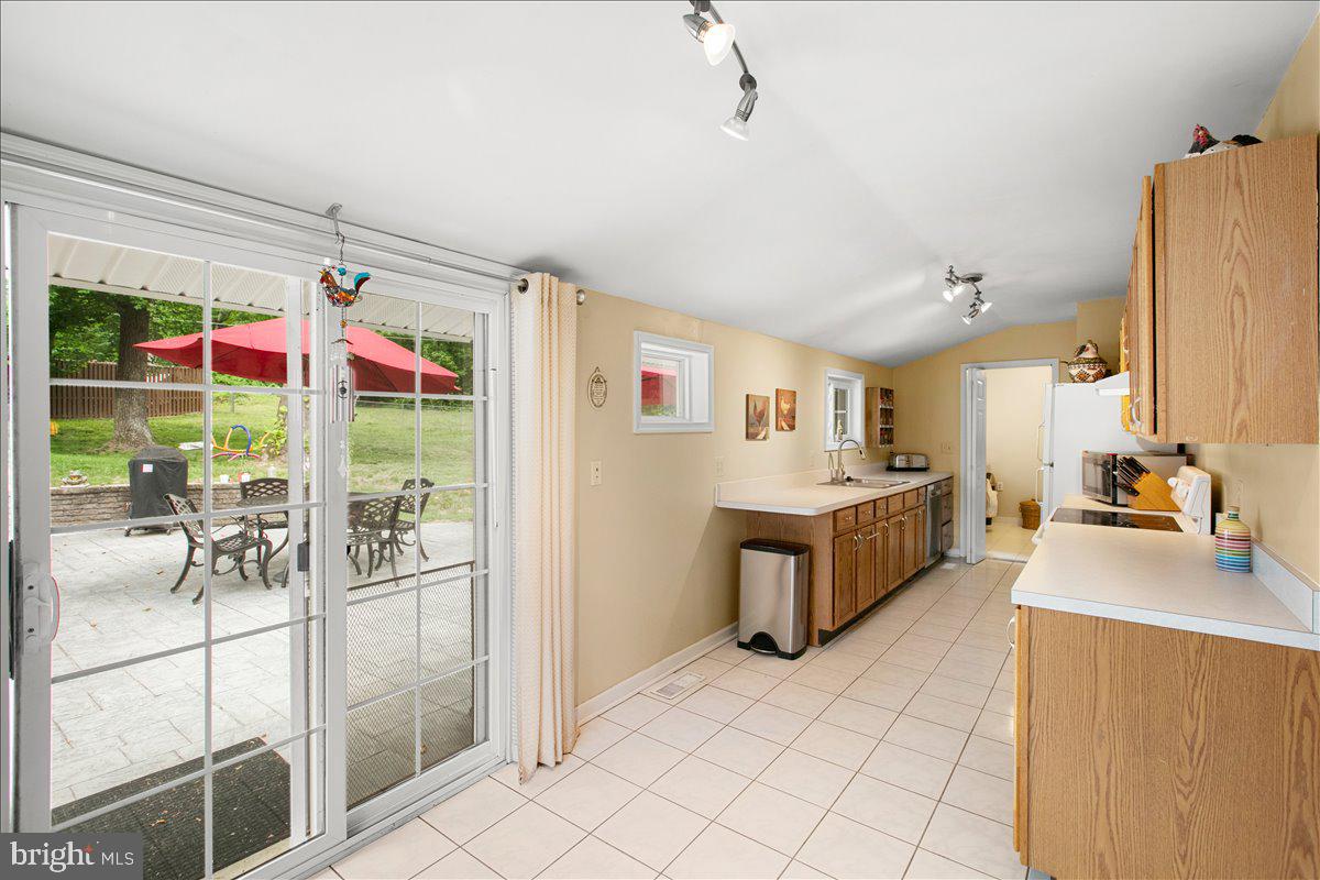 19266 Mockingbird Heights Road Triangle, VA 22172 - Photo 11 of 35 a large white kitchen with a large window and stainless steel appliances