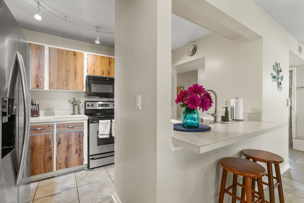 2 Cartagena Court St. Augustine, FL 32086 - Photo 20 of 49 a kitchen with stainless steel appliances kitchen island granite countertop a refrigerator a sink dishwasher and white cabinets with wooden floor