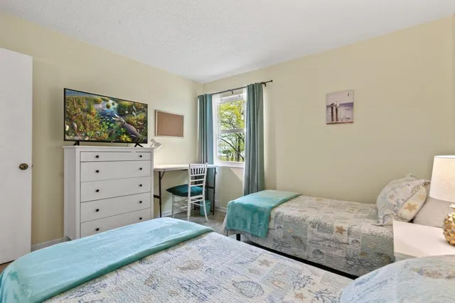 a bedroom with a bed and a lamp on the dresser