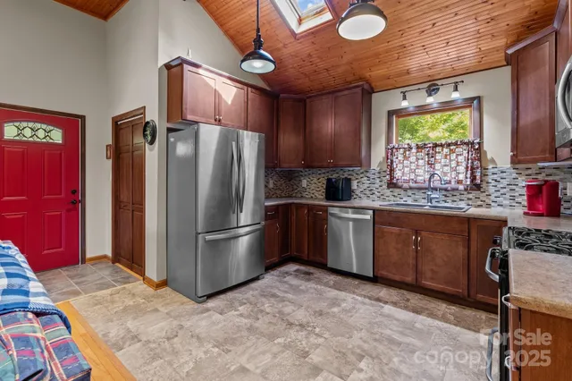 a kitchen with stainless steel appliances granite countertop a refrigerator sink stove microwave and cabinets