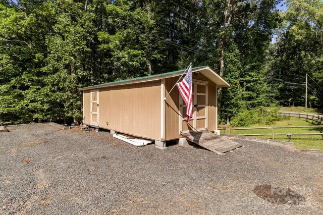 an aerial view of residential house with outdoor space and trees all around
