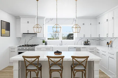 a kitchen with stainless steel appliances a stove a table and chairs