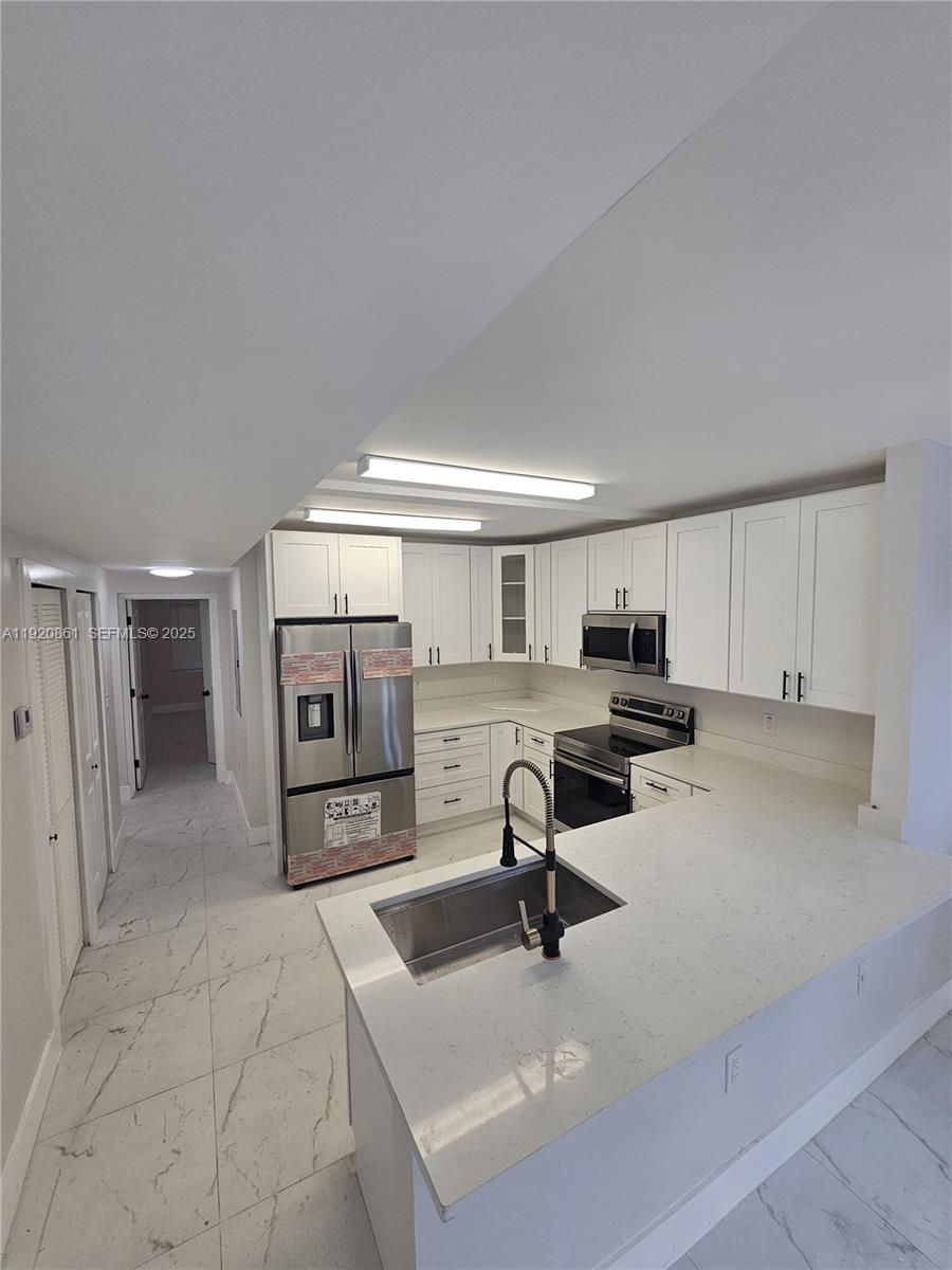 1361 Northwest 29th Terrace Miami, FL 33142 - Photo 3 of 7 a view of a kitchen with a sink and a refrigerator
